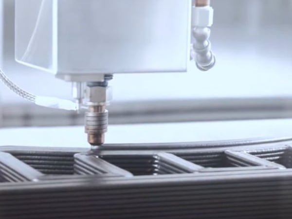 A futuristic image of a robotic arm servicing a bank of 3D printers.